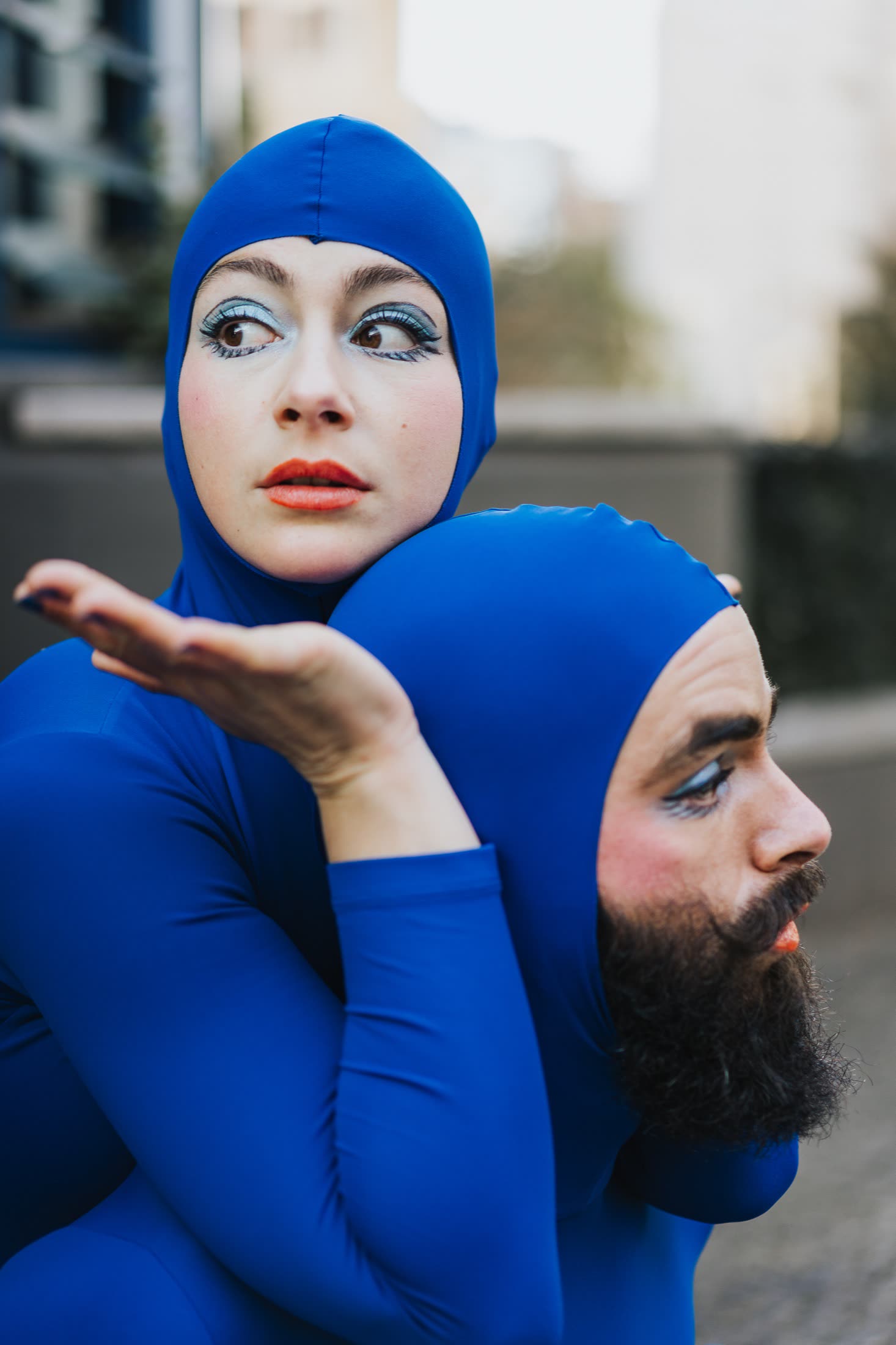 Two performers in blue costumes embracing on stage, Blueprint