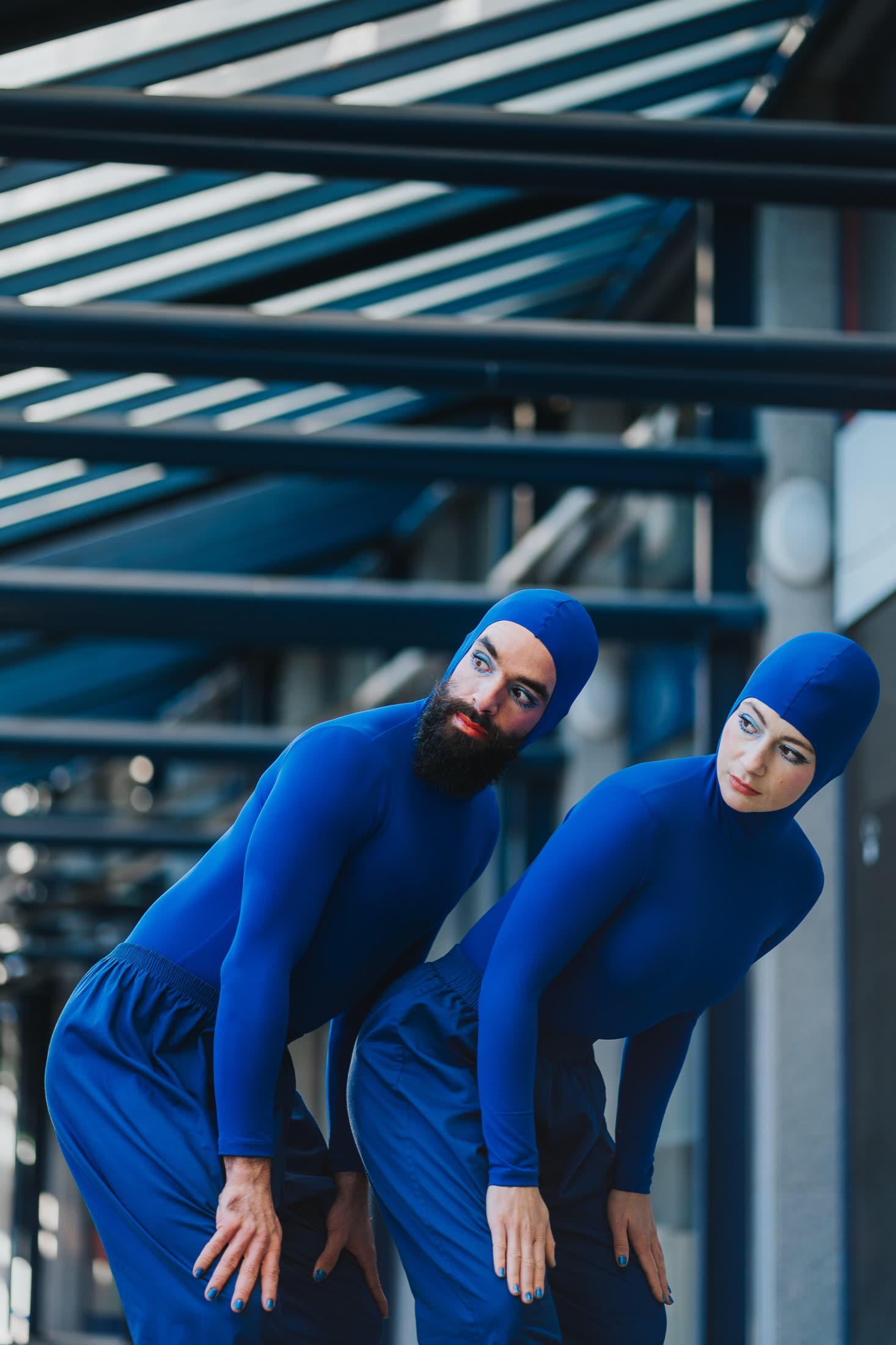 Two performers in blue bodysuits close together on stage, Blueprint