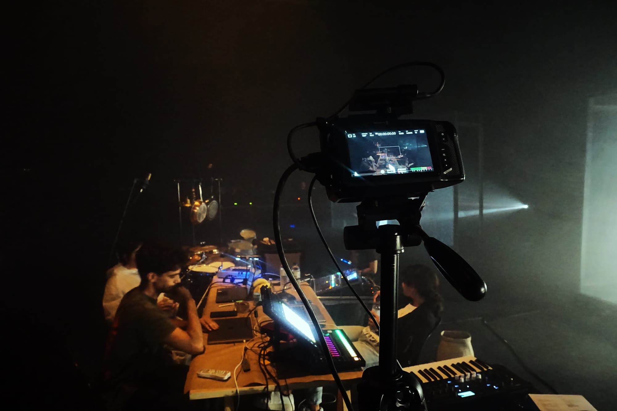 Performers and musicians on stage with projected visuals, Em.Pressão