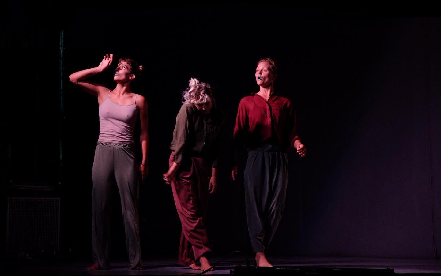 Three performers with blue-painted lips on a dark stage, Everyours