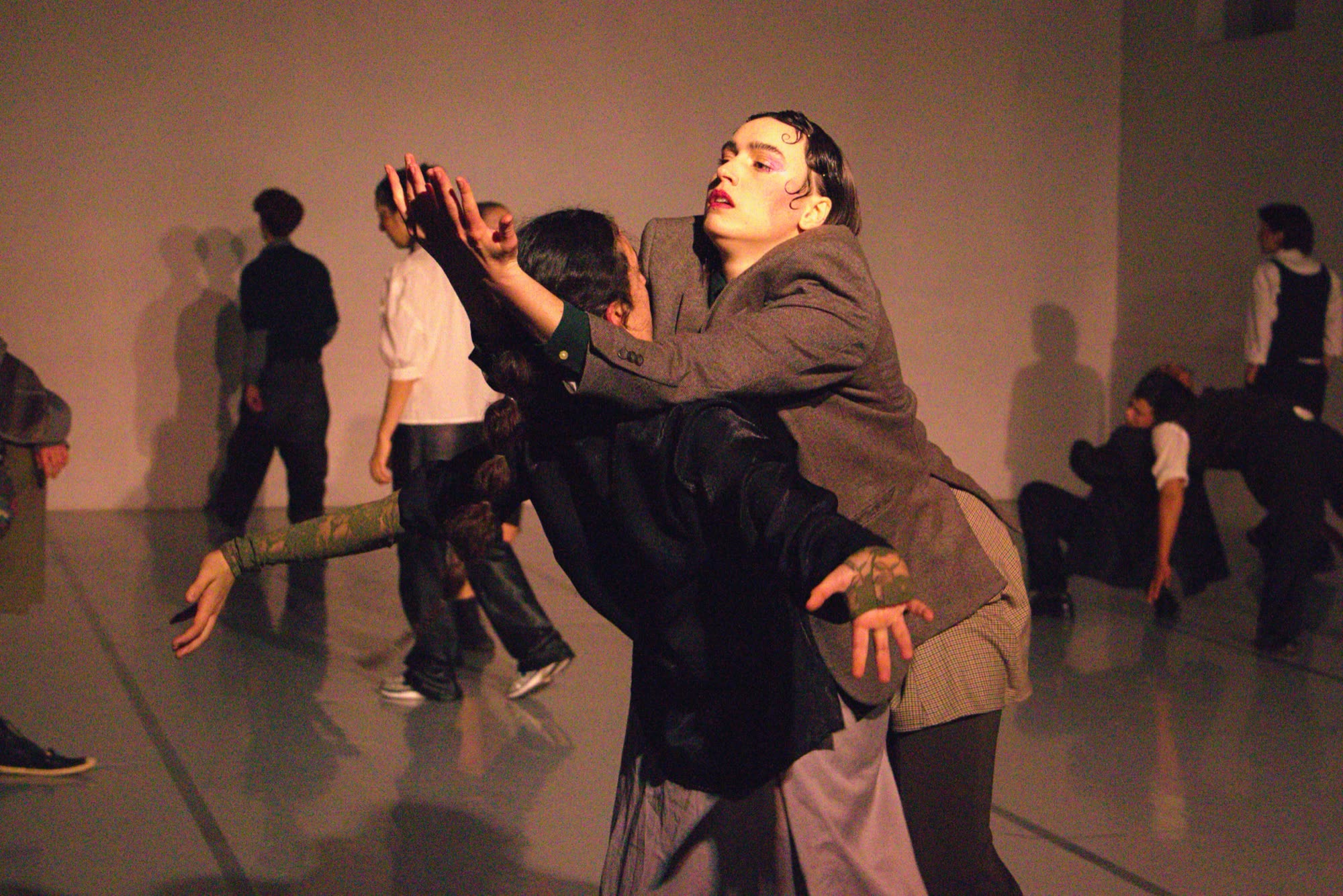 Two performers in a dimly lit rehearsal space, Lentidão