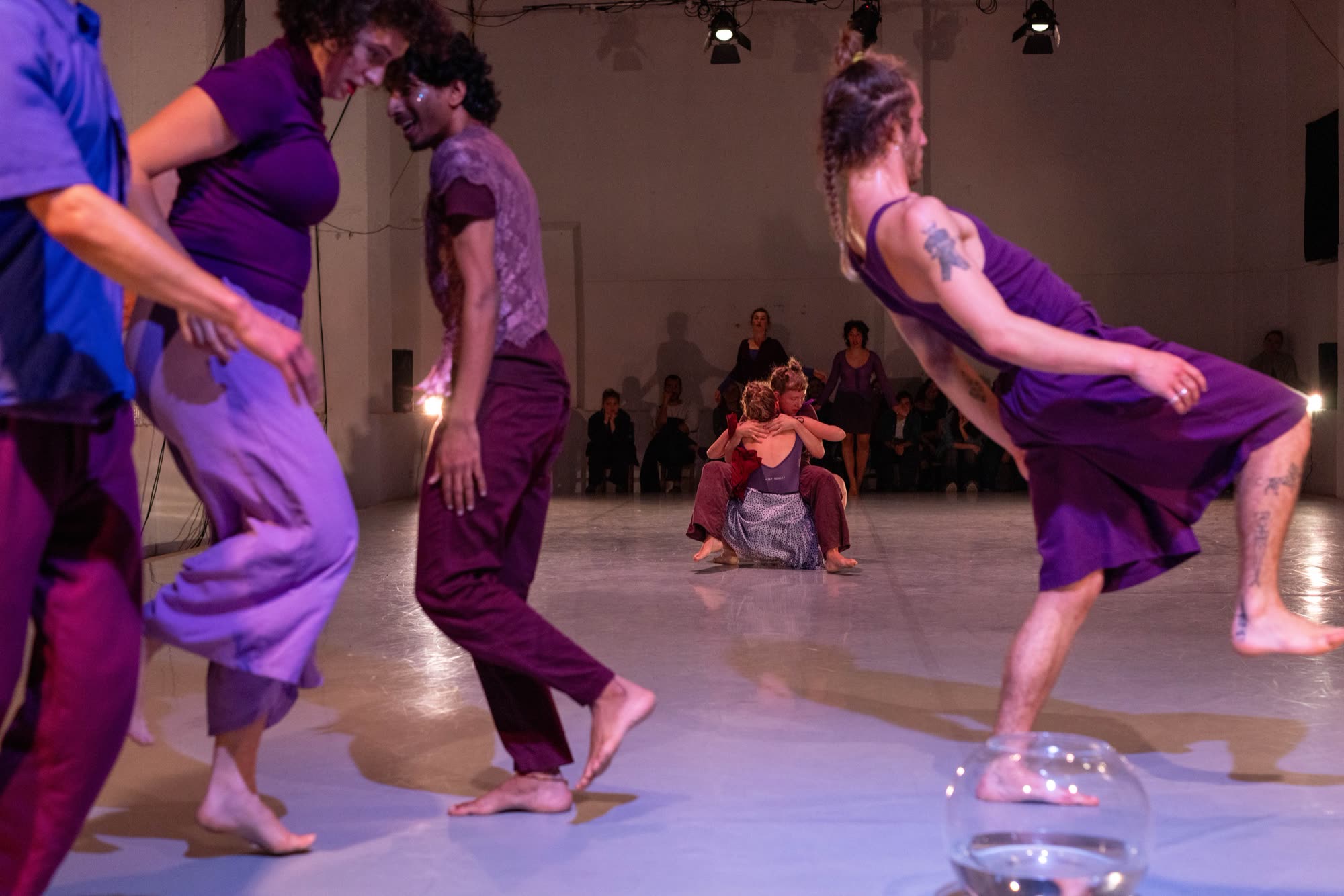 Ensemble of performers in purple costumes gathered on stage, Revoada