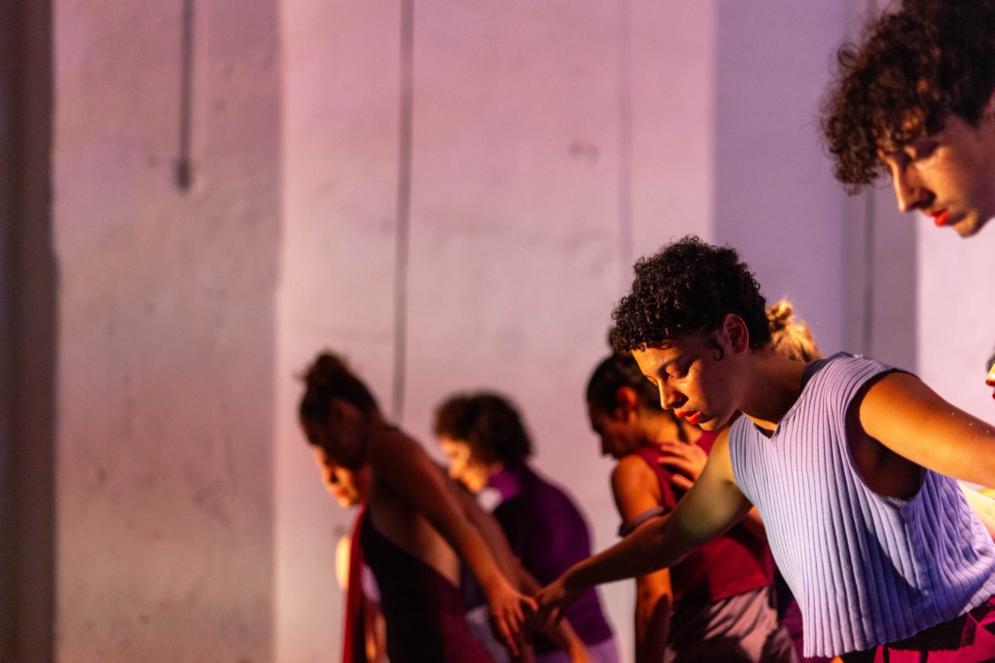 Performers moving together in purple costumes, Revoada